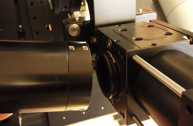 Tube lens assembly is attached to lower cubes on the microscope.